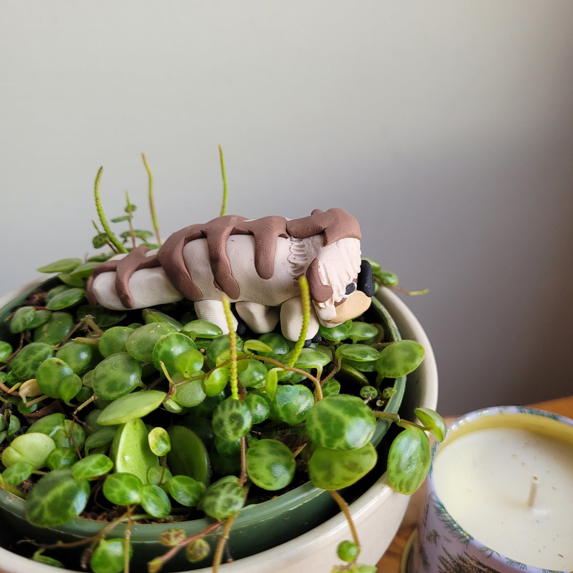 A side view of the Appa figurine nestled in a houseplant. A side view of the collectible Appa the flying bison figurine from the Avatar: The Last Airbender cartoon.